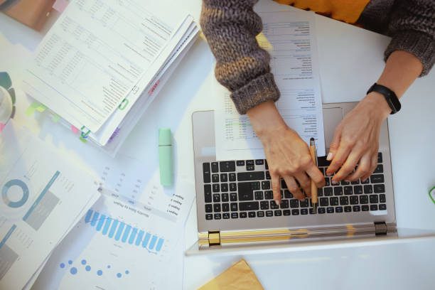 Une comptable, armée de documents et d'un ordinateur portable - journée de solidarité - Activ Consulting